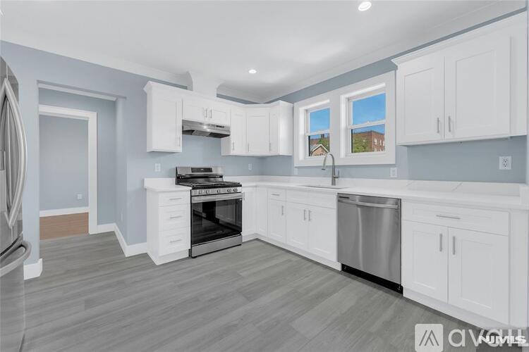 A kitchen with white cabinets and a stainless steel dishwasher.