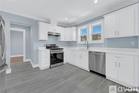 A kitchen with white cabinets and a stainless steel dishwasher.