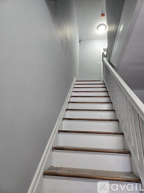 A staircase with wooden steps and white railings.