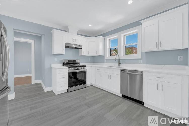 A kitchen with white cabinets and a stainless steel dishwasher.