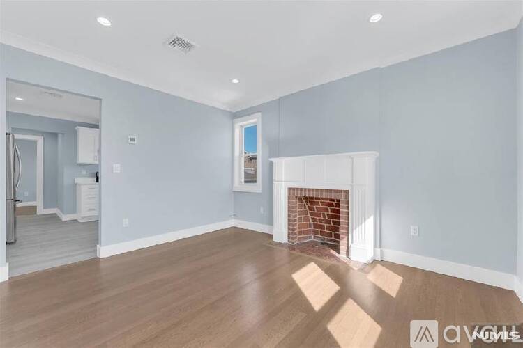 A living room with a fireplace and a painting on the wall.