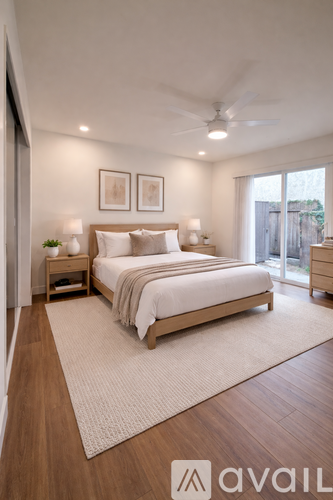 A bedroom with a large bed and a ceiling fan.