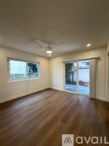 A room with wooden flooring and a ceiling fan.