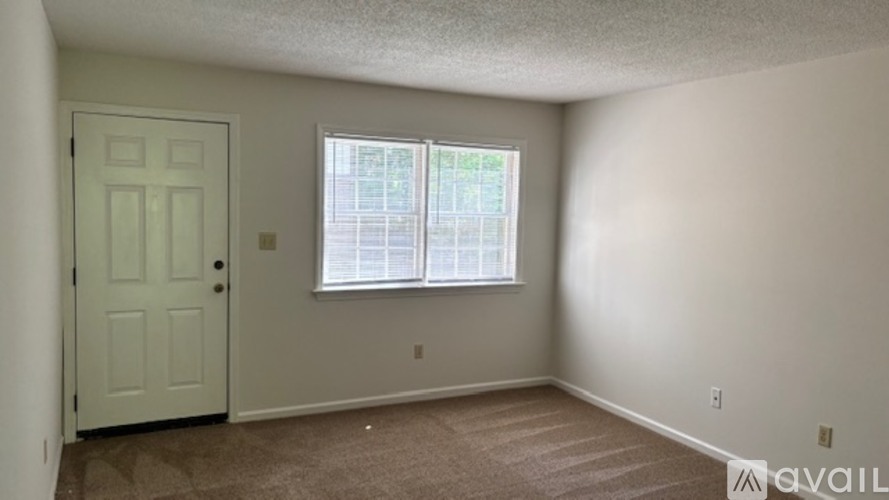 A room with a door and a window with blinds.