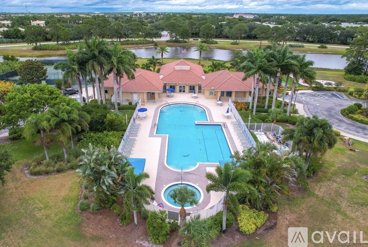 A large house with a pool surrounded by palm trees.