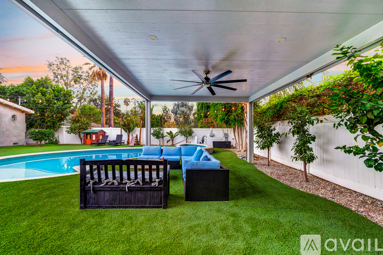 A patio with a pool and a ceiling fan.