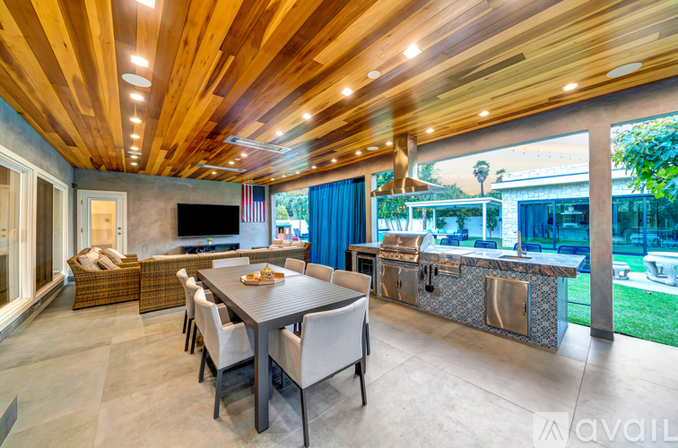 A modern dining room with a wooden ceiling and a glass table.