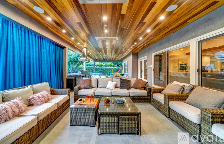 A modern living room with a wooden ceiling and a large sectional sofa.