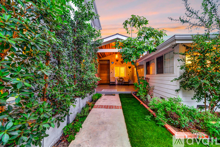 A house with a white exterior and a garden in front.