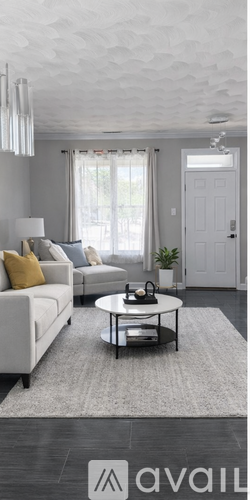 A living room with a white sofa and a grey coffee table.