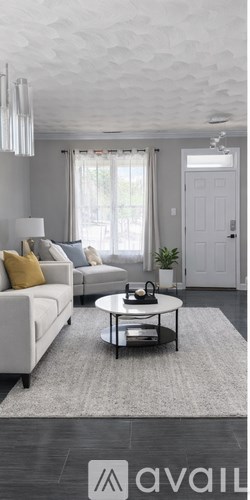 A living room with a white sofa and a grey coffee table.