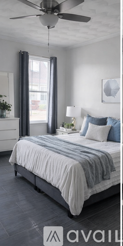 A bedroom with a bed, nightstand, and a ceiling fan.