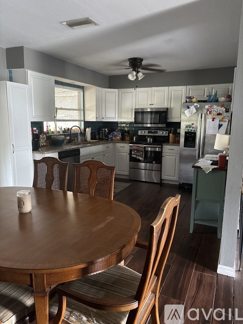 A kitchen with a table and chairs in front of it.