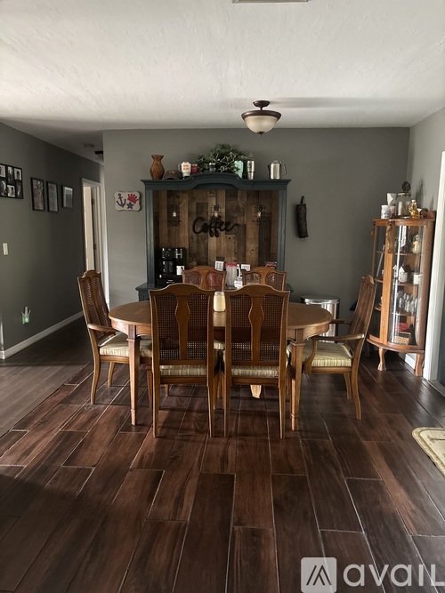 A dining room with a wooden table and chairs.