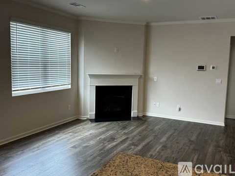 A living room with a fireplace and a rug on the floor.