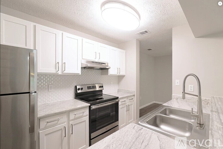 A kitchen with white cabinets and a stainless steel refrigerator.