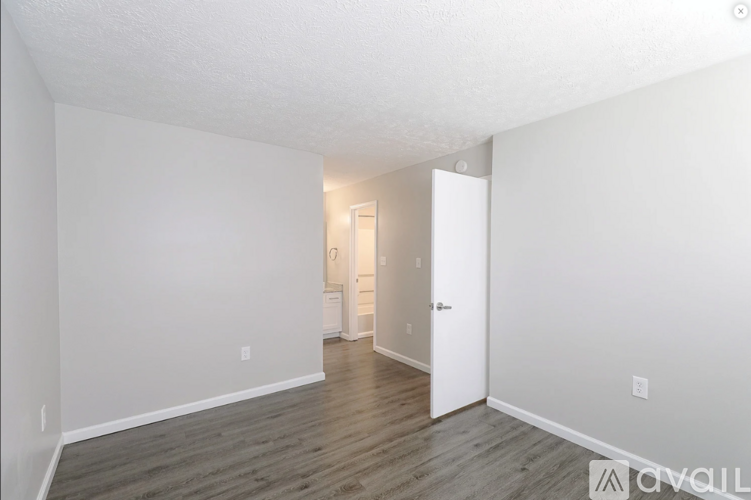 A spacious room with a doorway leading to another room.