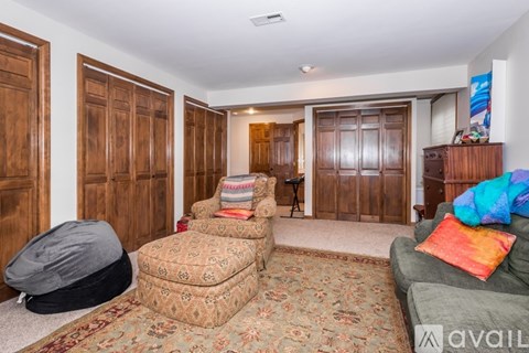 A living room with a grey couch and a rug.