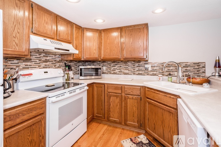 A kitchen with wooden cabinets and a white countertop.
