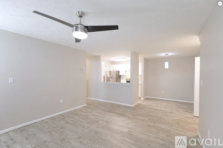 A spacious room with a ceiling fan and lighting fixtures.