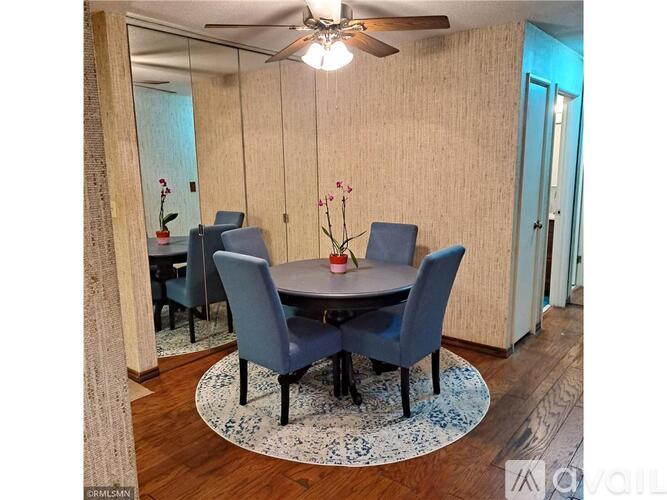 A dining room with a round table and chairs.