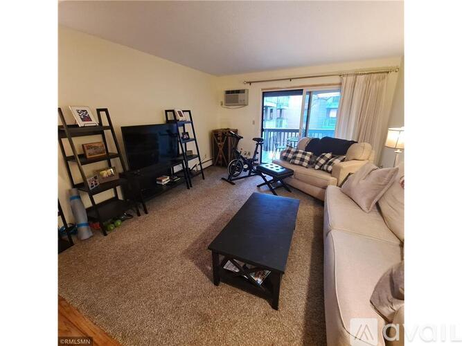 A living room with a couch, a coffee table, and a television.