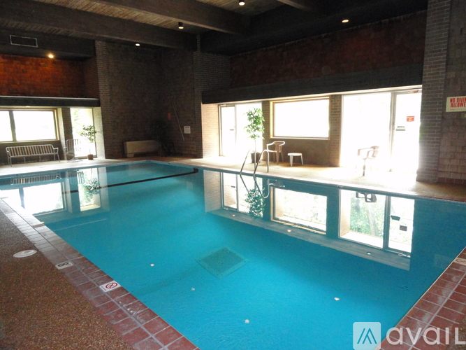 A large indoor swimming pool with a brick border.