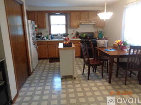 A kitchen with a checkered floor and wooden cabinets.