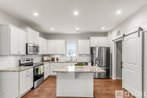 A kitchen with white cabinets and a granite countertop.