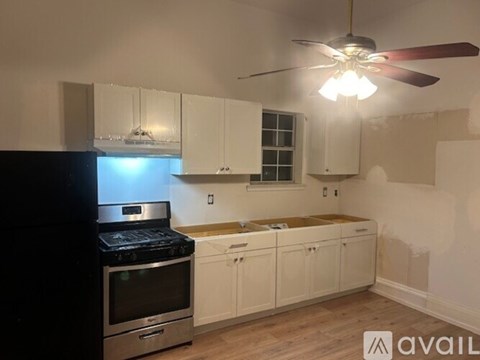 A kitchen with a black stove top oven and white cabinets.
