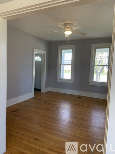 A room with wooden floors and a ceiling fan.