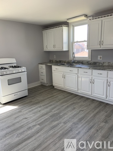 A kitchen with white cabinets and a white stove.