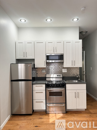 A kitchen with white cabinets and stainless steel appliances.