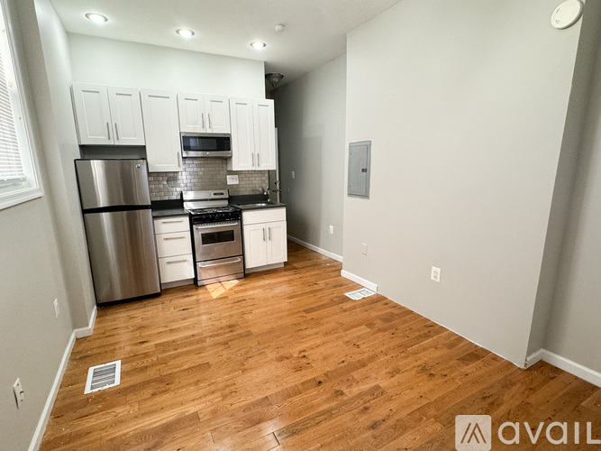 A kitchen with wooden floors and stainless steel appliances.
