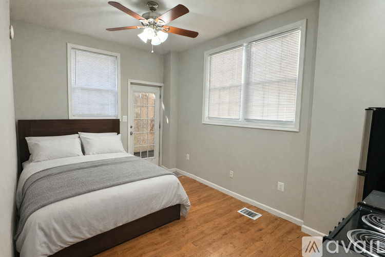 A bedroom with a bed, a ceiling fan, and a window.