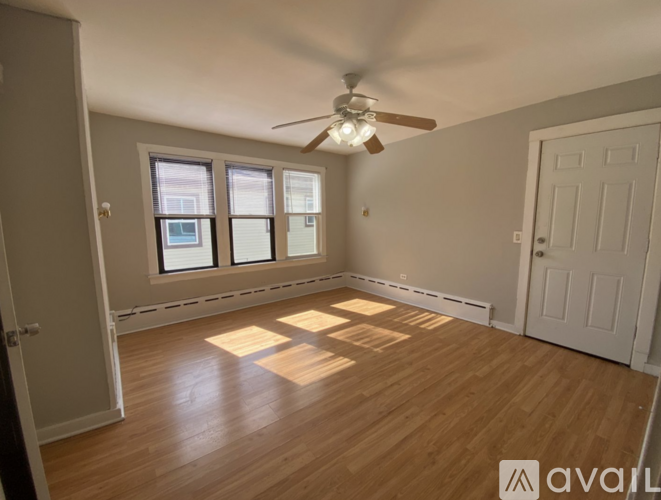 A room with wooden floors and a ceiling fan.