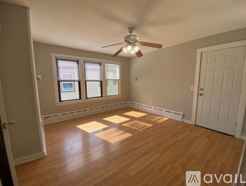 A room with wooden floors and a ceiling fan.