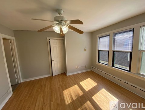 A room with a ceiling fan and wooden flooring.