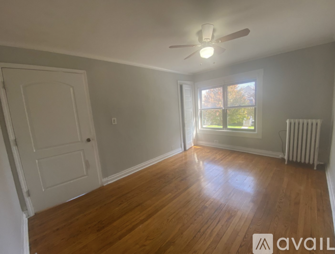 A room with wooden floors and a ceiling fan.