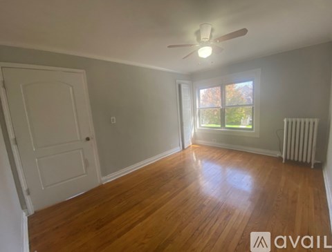 A room with wooden floors and a ceiling fan.