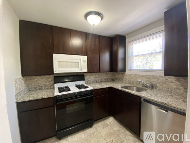 A kitchen with brown cabinets and a granite countertop.
