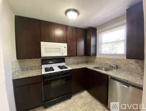 A kitchen with brown cabinets and a granite countertop.