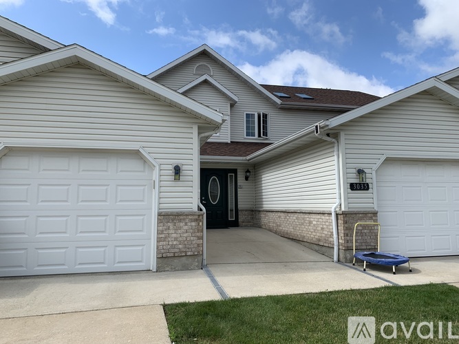 A two-story house with a garage and a driveway.