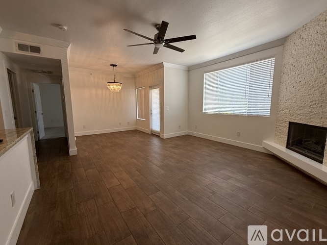 A living room with a fireplace and a ceiling fan.