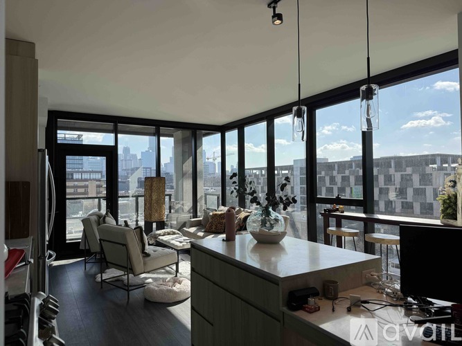 A modern living room with a view of the cityscape outside the large windows.