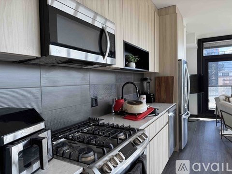 A modern kitchen with a stove top oven and a microwave above it.