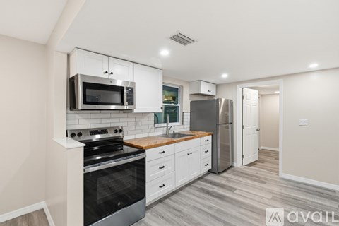 A modern kitchen with a stove, microwave, and refrigerator.