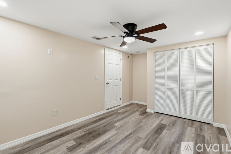 A room with a ceiling fan and sliding doors.