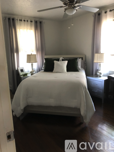 A bedroom with a large bed and a ceiling fan.