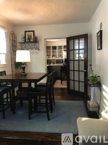 A dining room with a table and chairs.